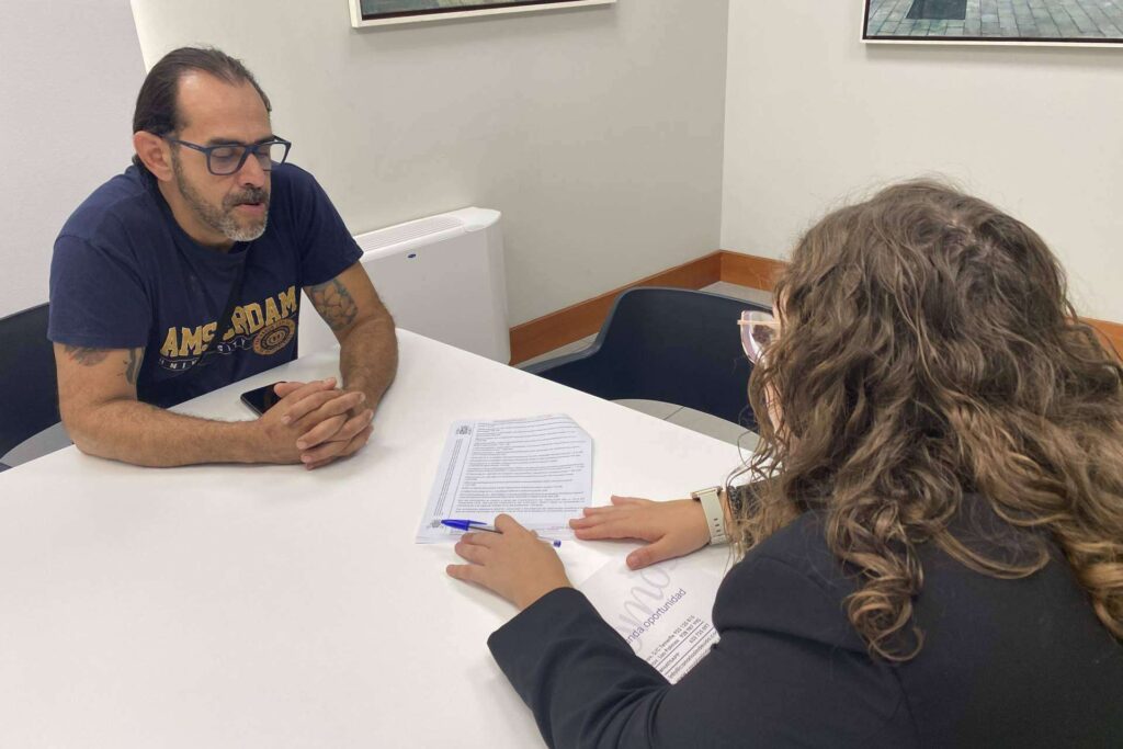 Un cliente y una asesora revisan documentos sobre la mesa en una oficina