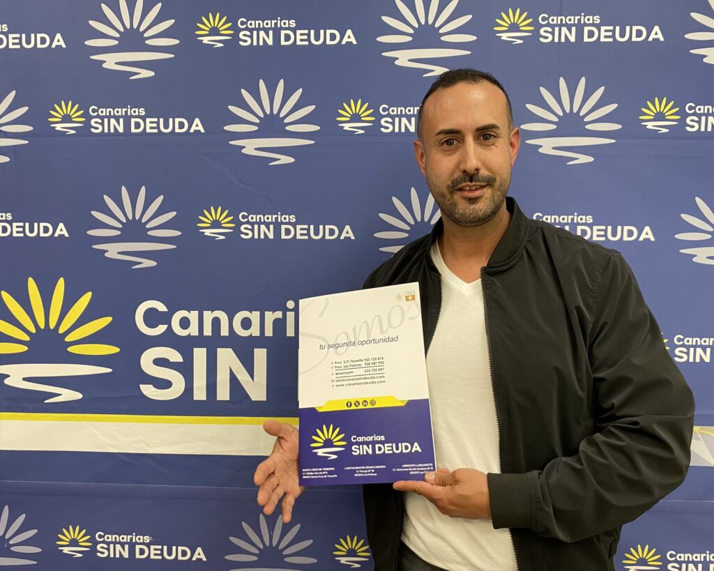 Un cliente sostiene el folleto informativo de la Ley de Segunda Oportunidad delante del fondo corporativo de Sin Deuda Group