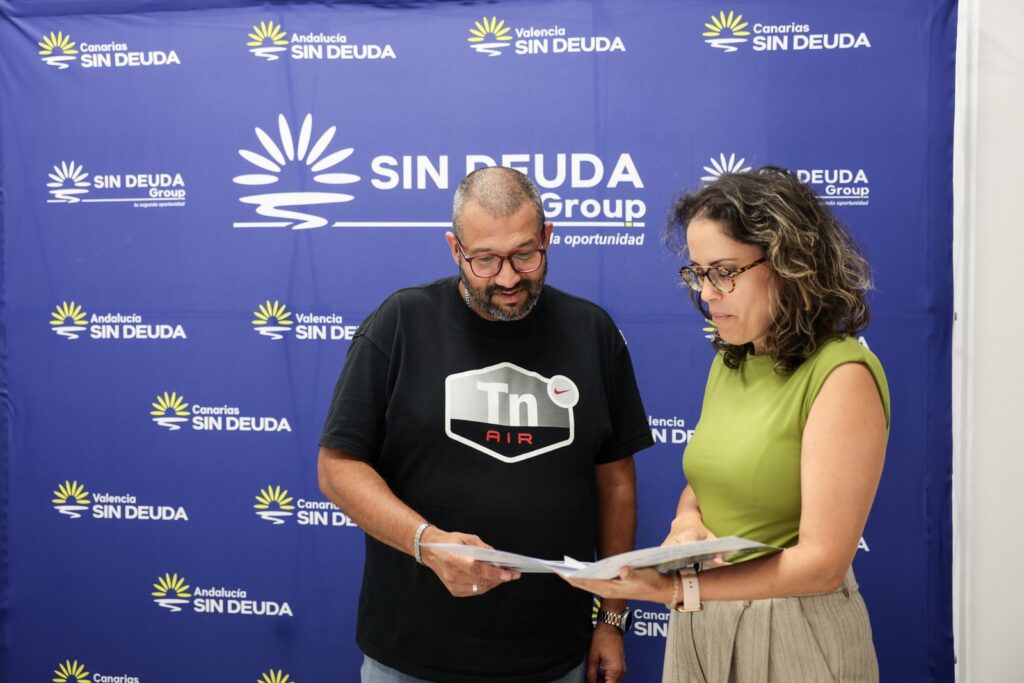 Dos personas revisan juntas un expediente delante del fondo corporativo de Sin Deuda Group
