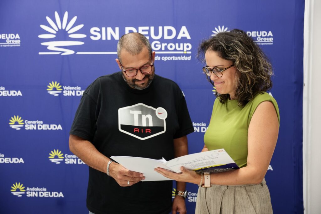 Dos personas revisan juntas la documentación de un caso delante del fondo corporativo de Sin Deuda Group