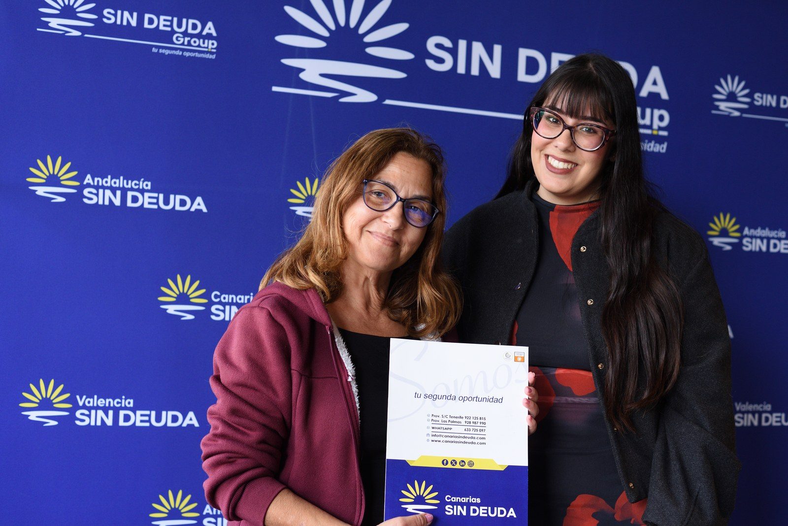 Oneida, a la izquierda, sosteniendo la documentación de su caso en la entrega de su expediente