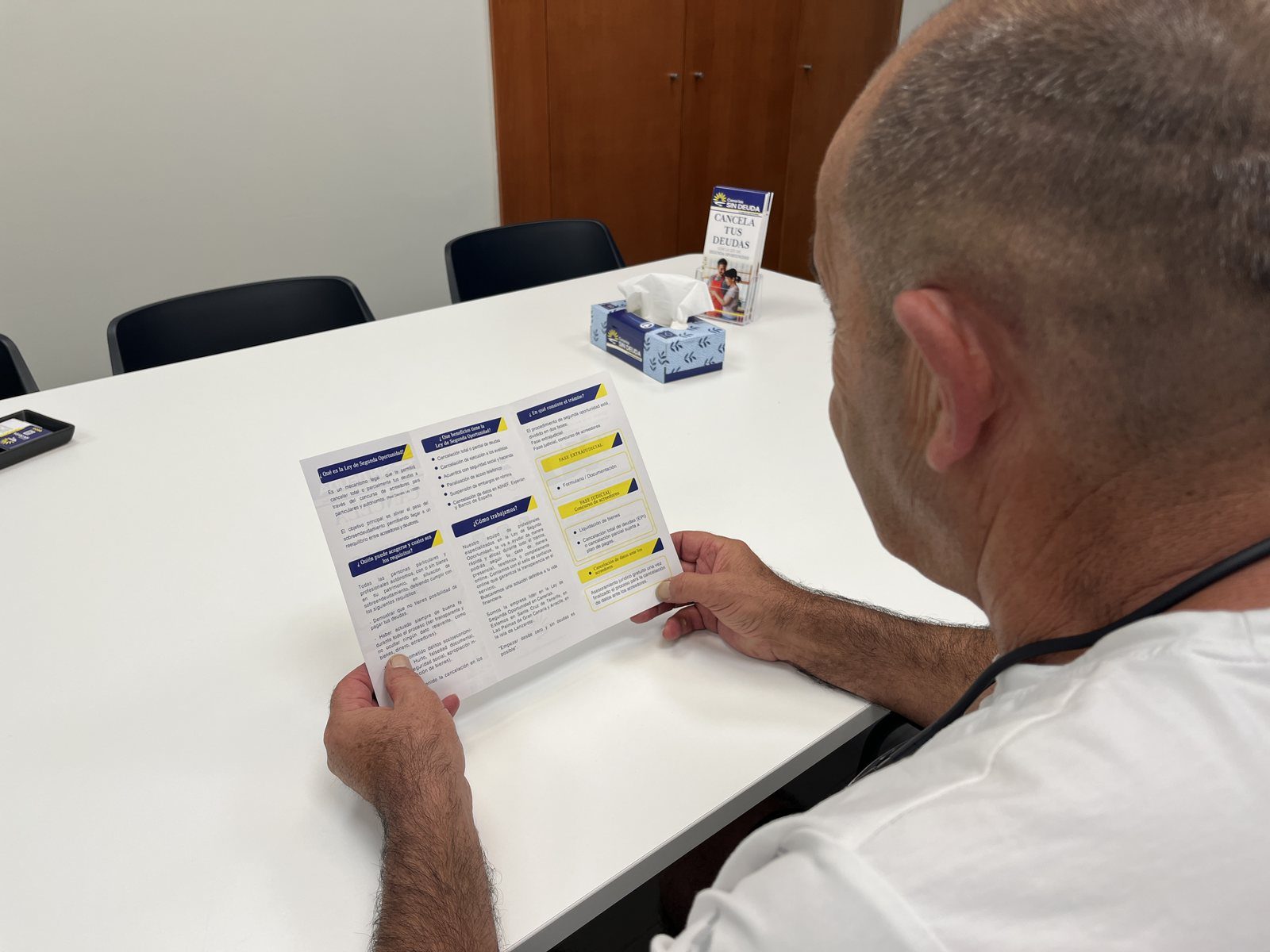 Persona revisando un documento con tablas y apartados marcados durante el análisis de su situación de deudas